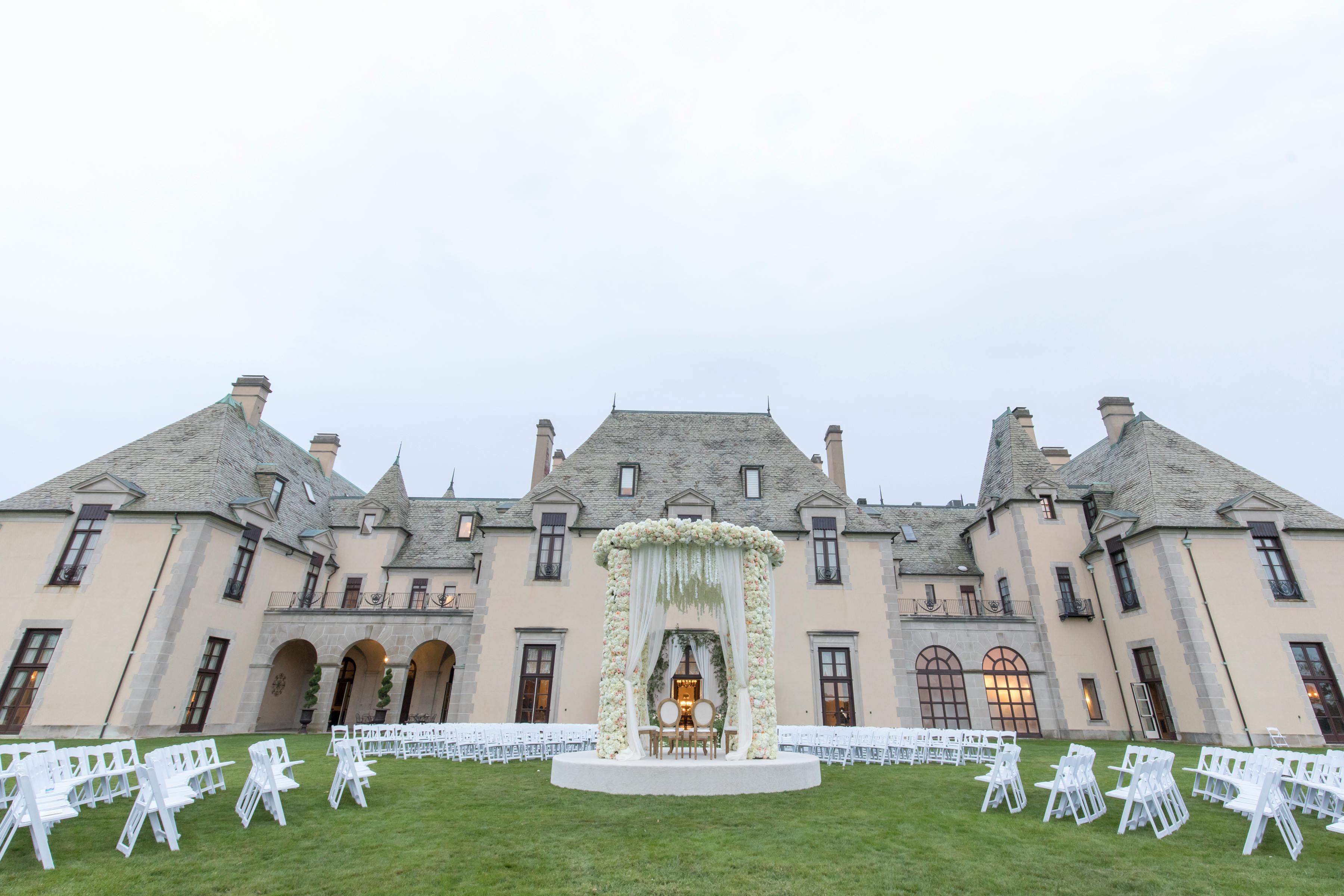 A massive castle with tables and chairs on the manicured grass