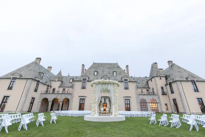A massive castle with tables and chairs on the manicured grass