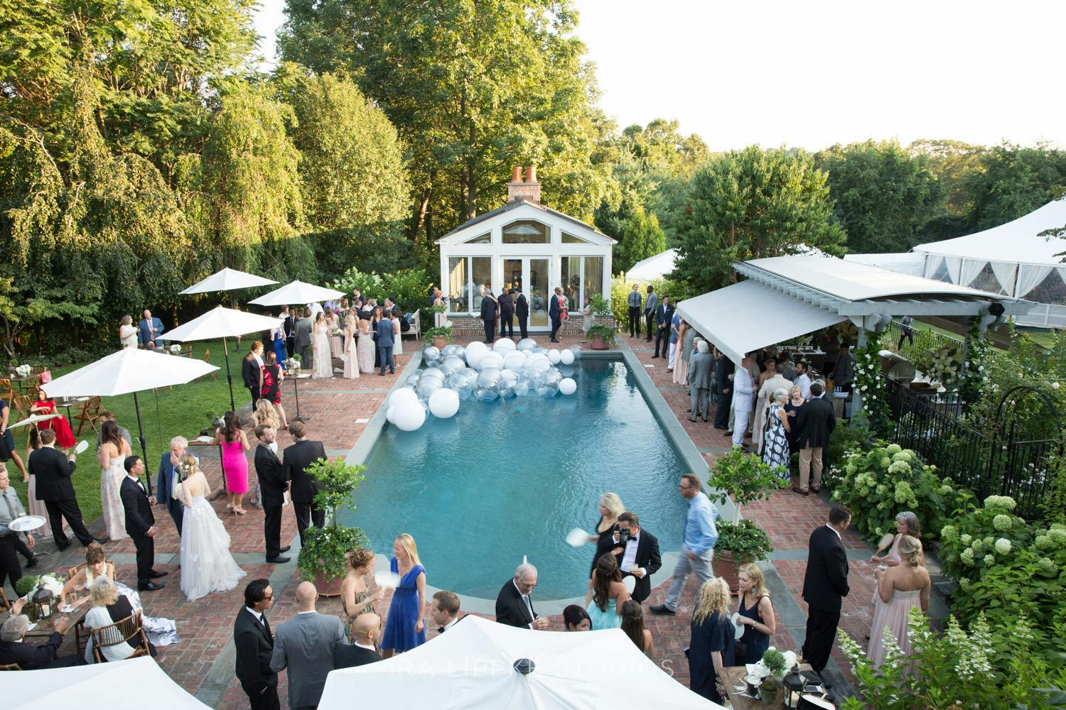 poolside cocktail parties with white umbrellas and floating orb decor