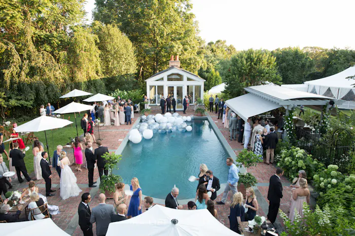 poolside cocktail parties with white umbrellas and floating orb decor