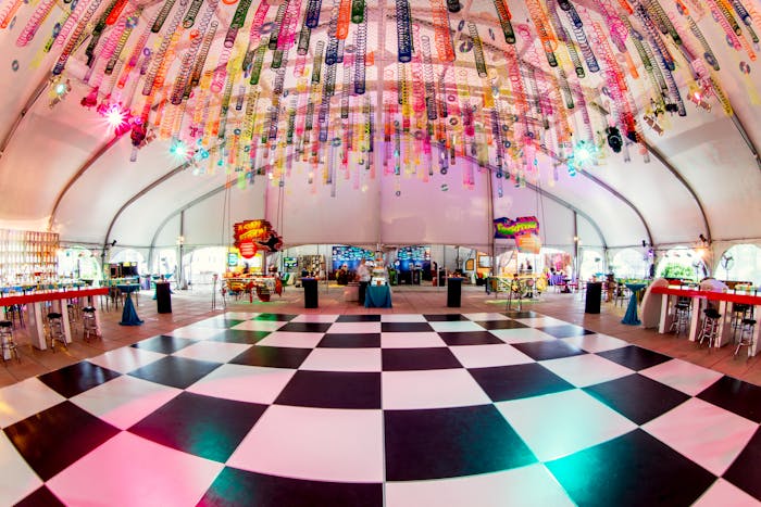 A fisheye view of a checker print dance floor with rainbow tinsel hanging above.
