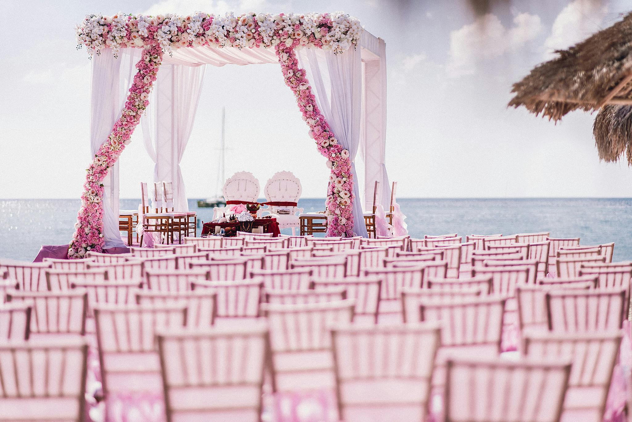 An all pink wedding with pink chairs and a pink archway. 
