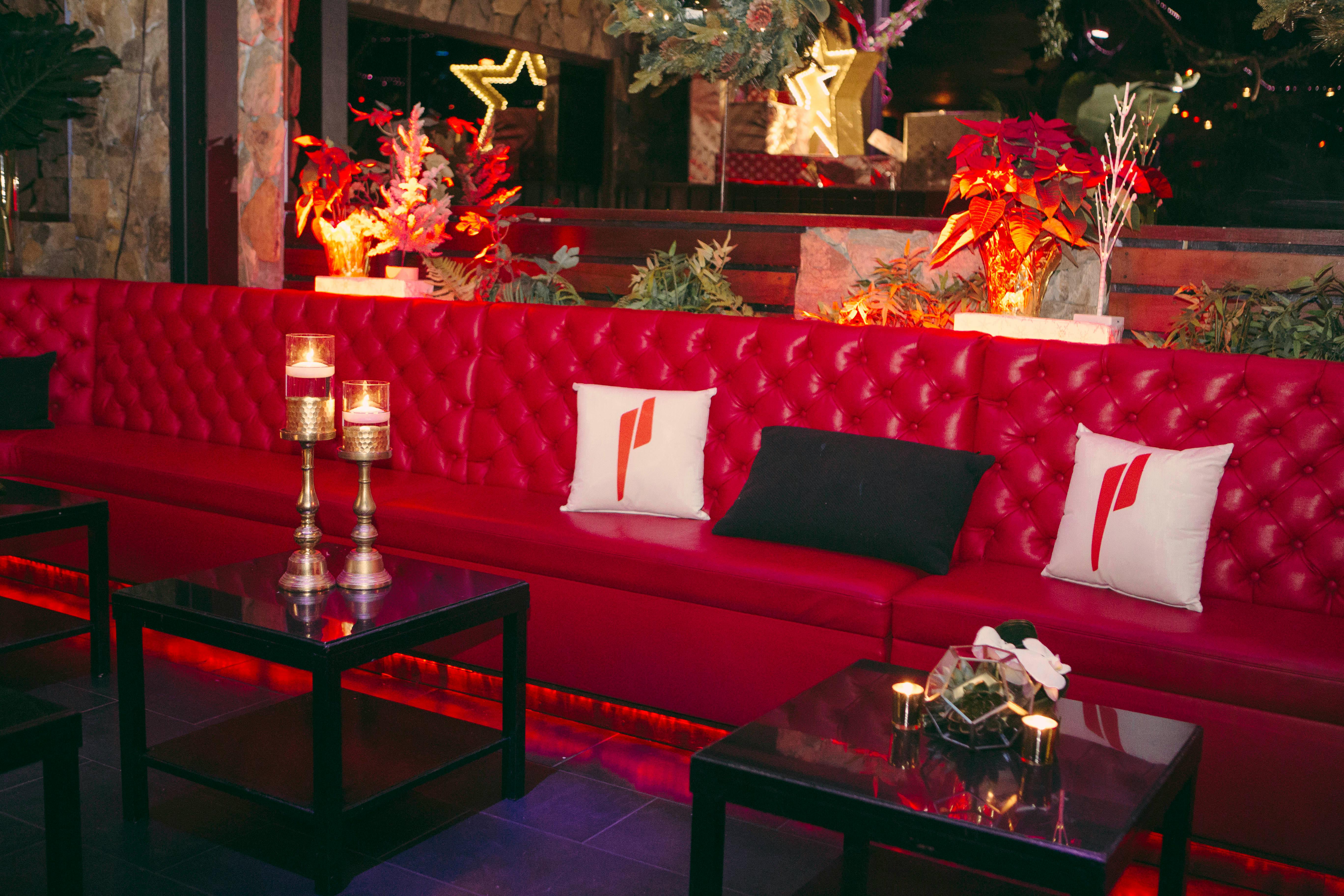 quilted red booth with pillows and candles 