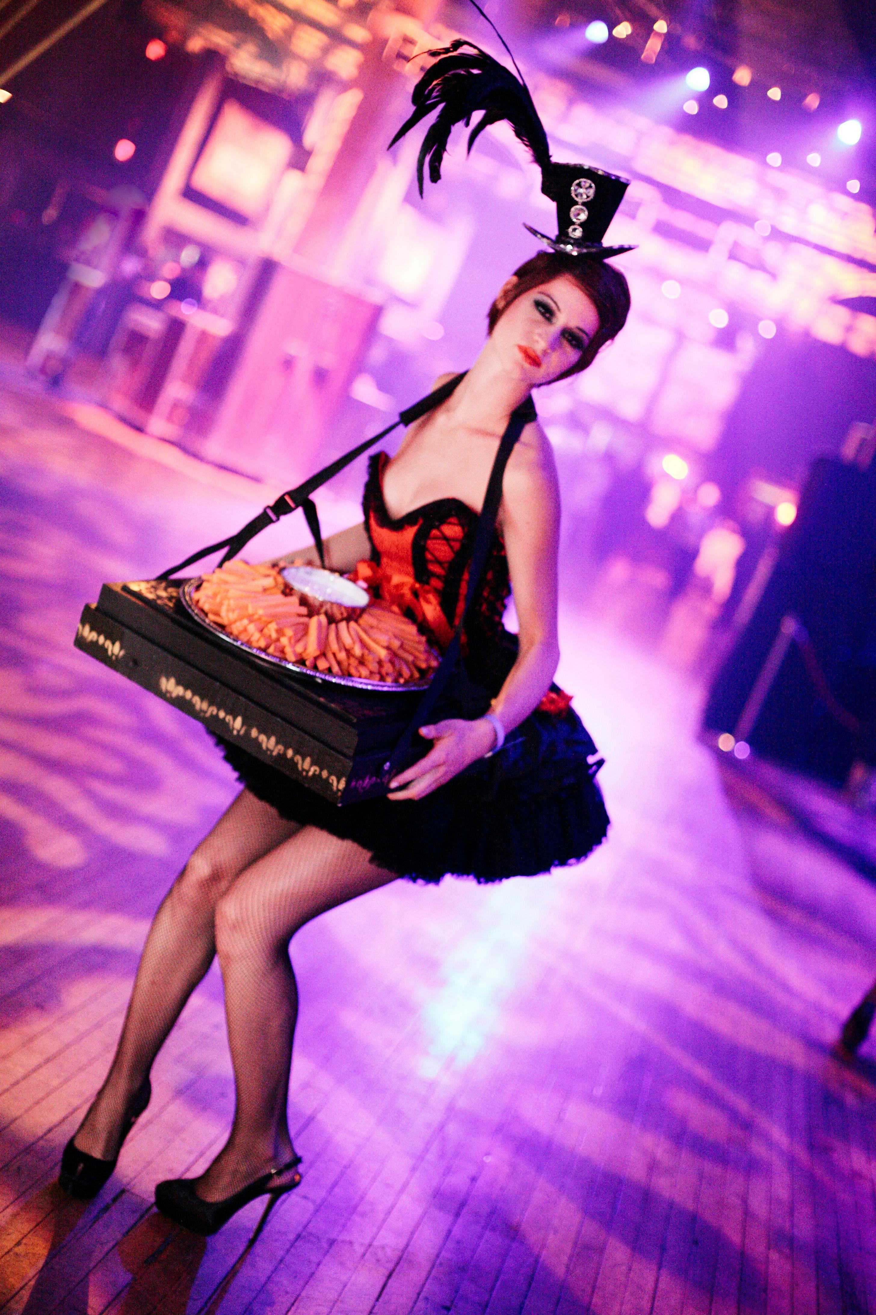 entertainer with appetizers on a tray and purple dance floor in background
