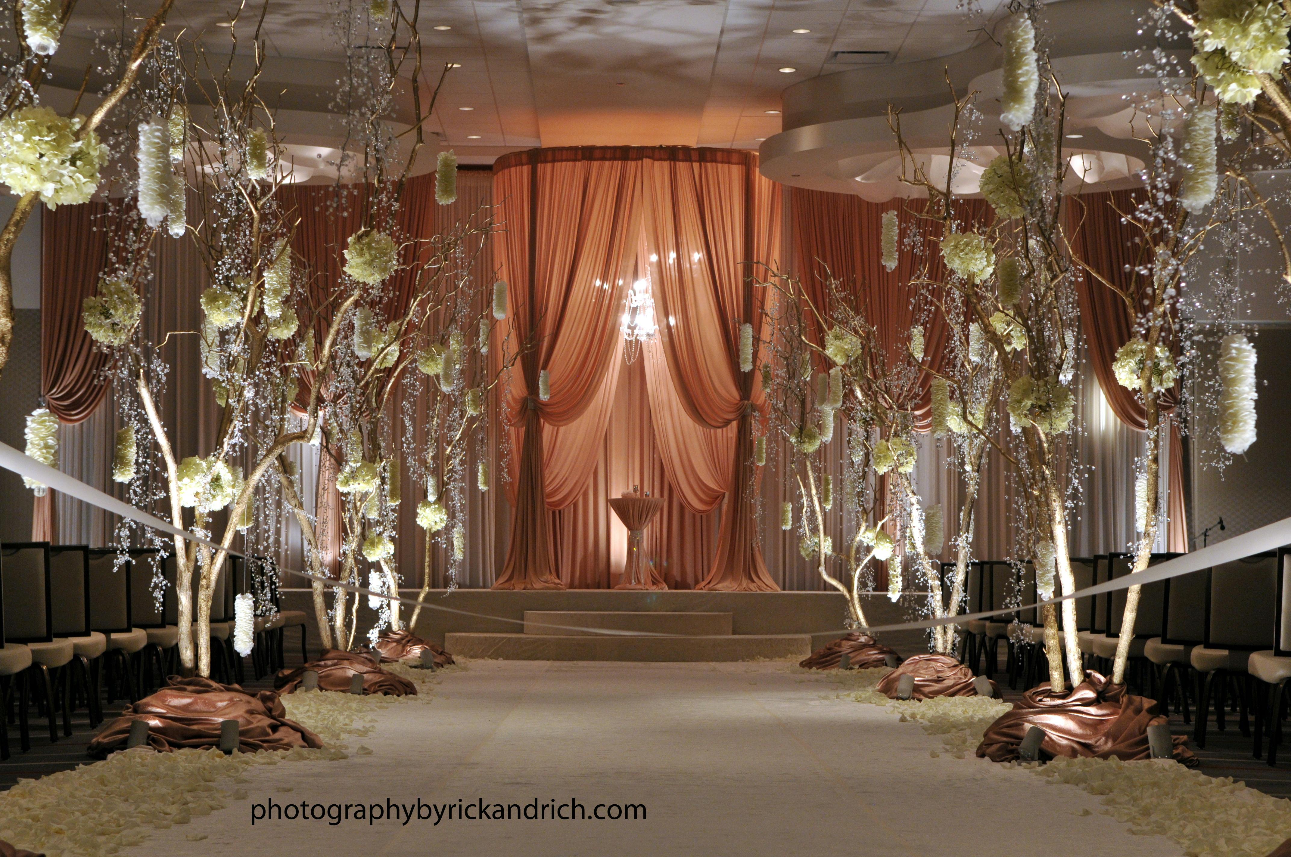 Yanni Design Studio Wedding Ceremony And Aisle Decor Partyslate Aisle Decor Features Large Trees With Flowers Intertwined Within The Branches Spotlights Are Used To