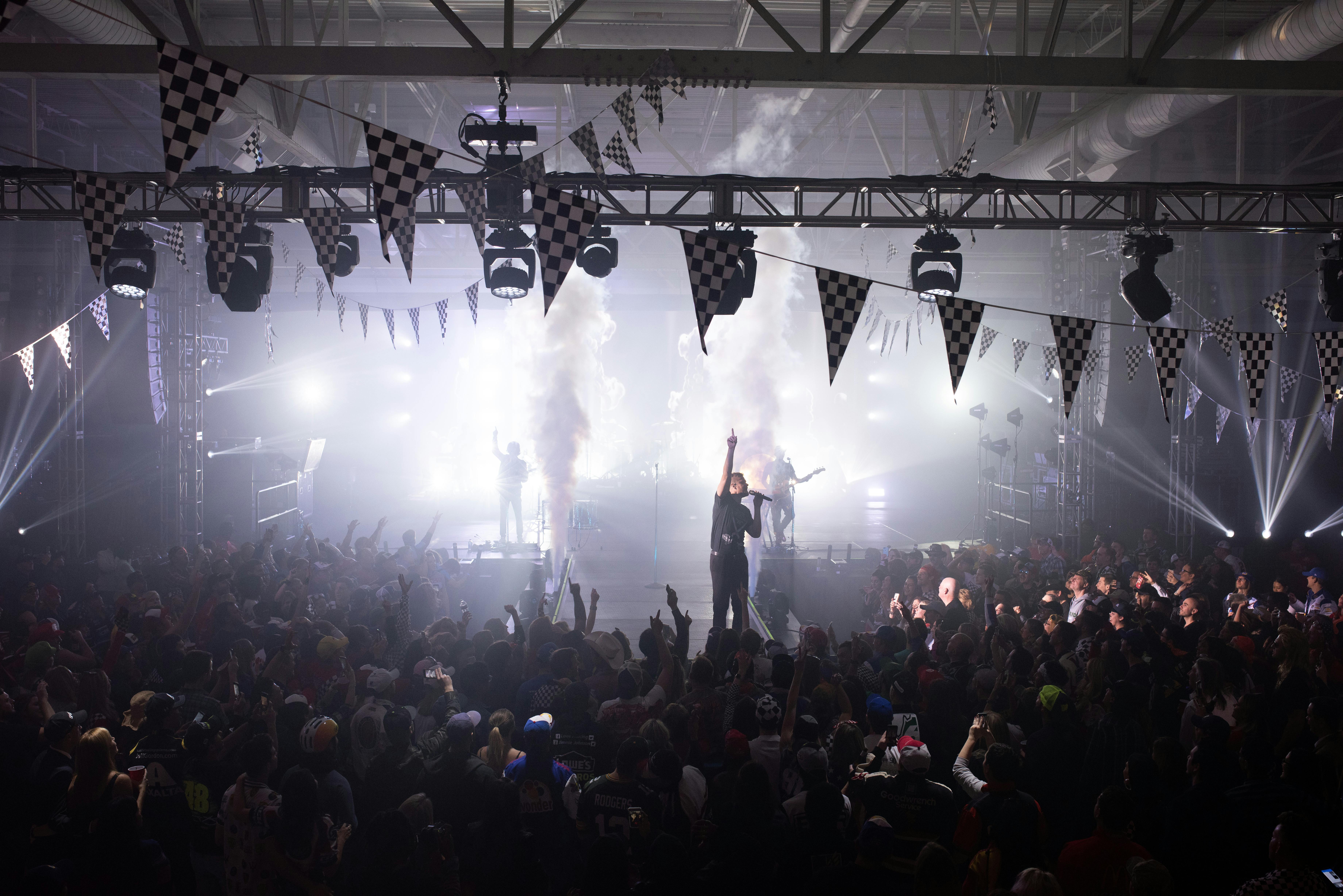 Imagine Dragons are on stage with white lighting around them