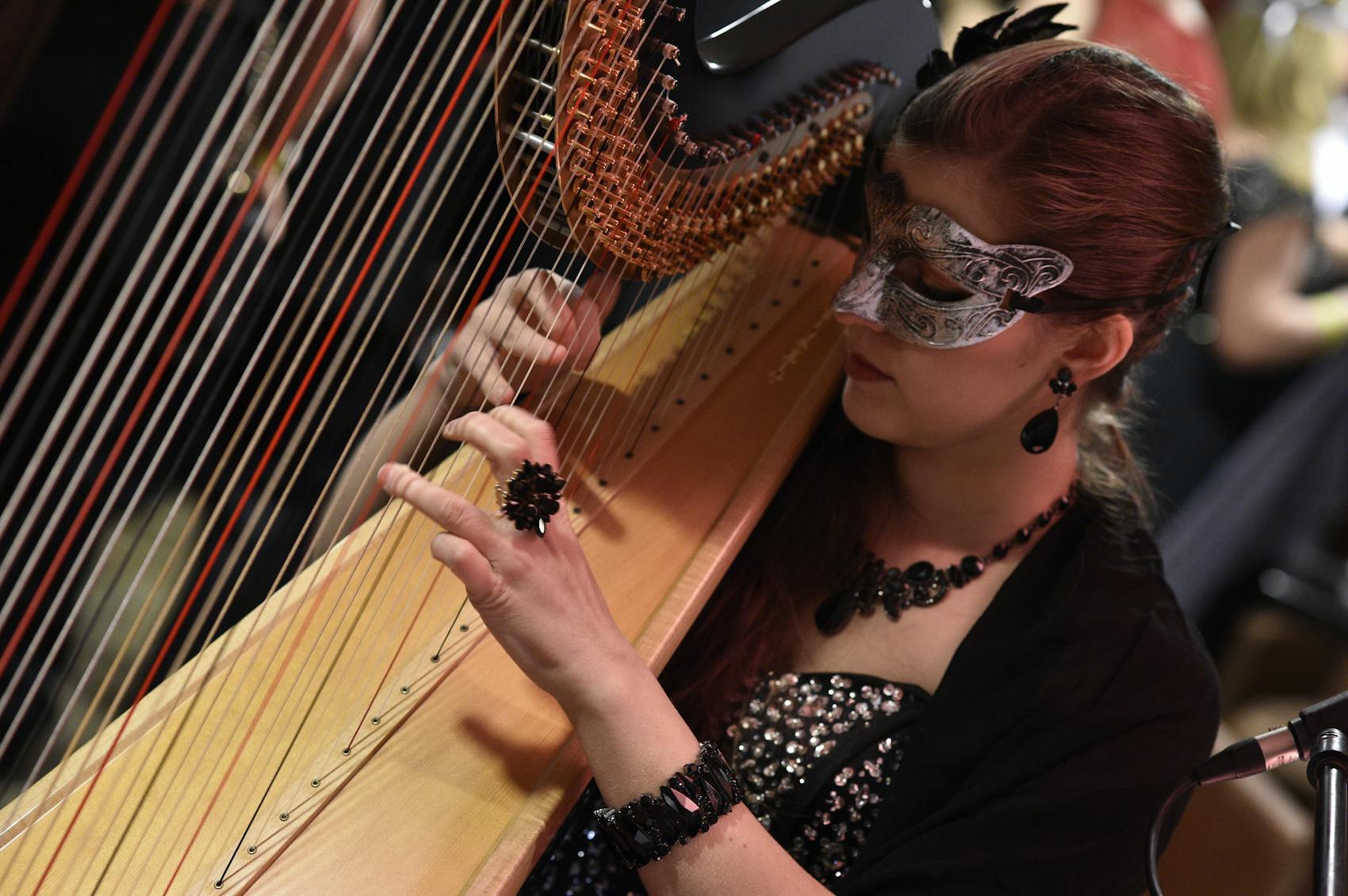 women wearing a mask plays harp