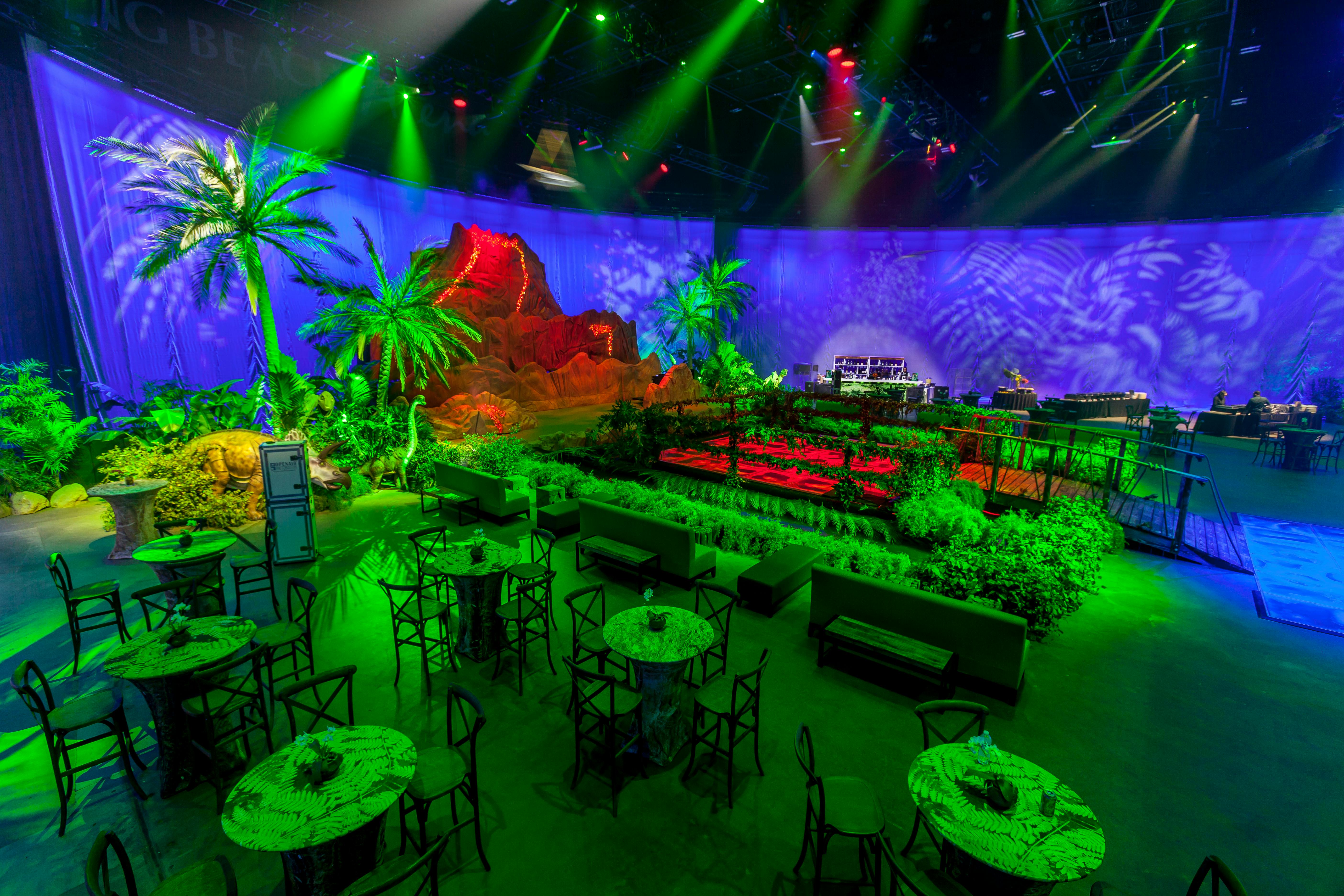 Jurassic Park themed party with rocks and leafy installations and greenn lighting | PartySlate