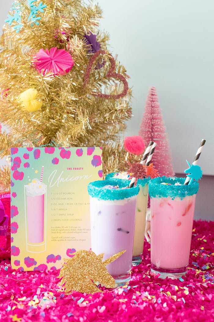 Colorful milkshakes in front of small gold Christmas tree | PartySlate