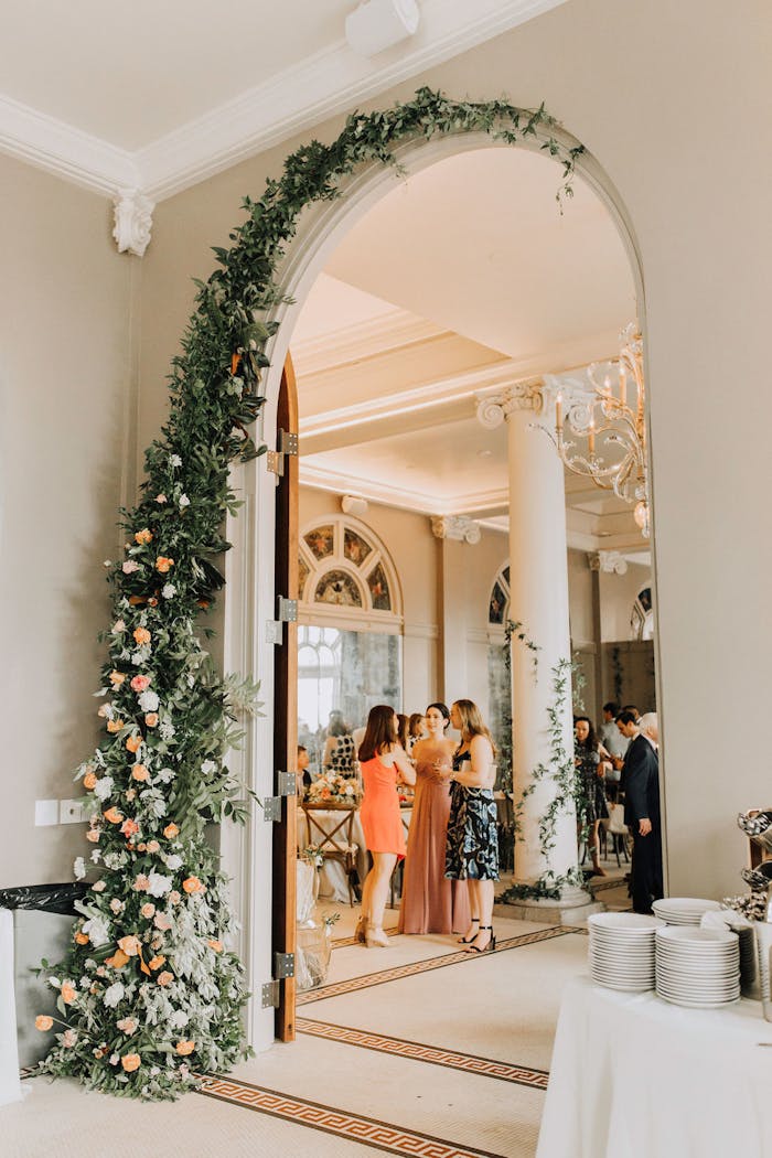 indoor archway lined with greenery and pink and white florals
