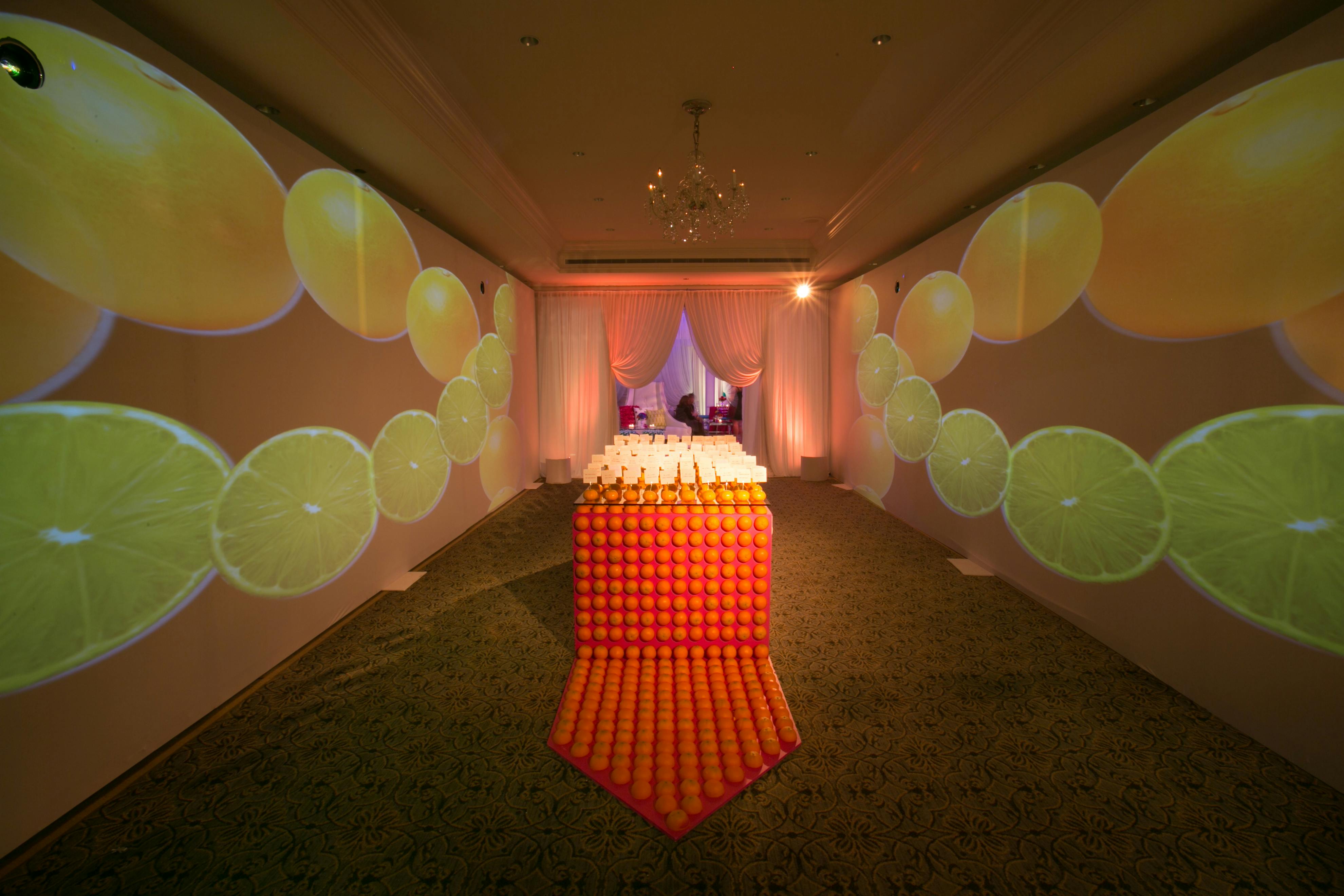 citrus projections flanking fresh orange decorated place card table