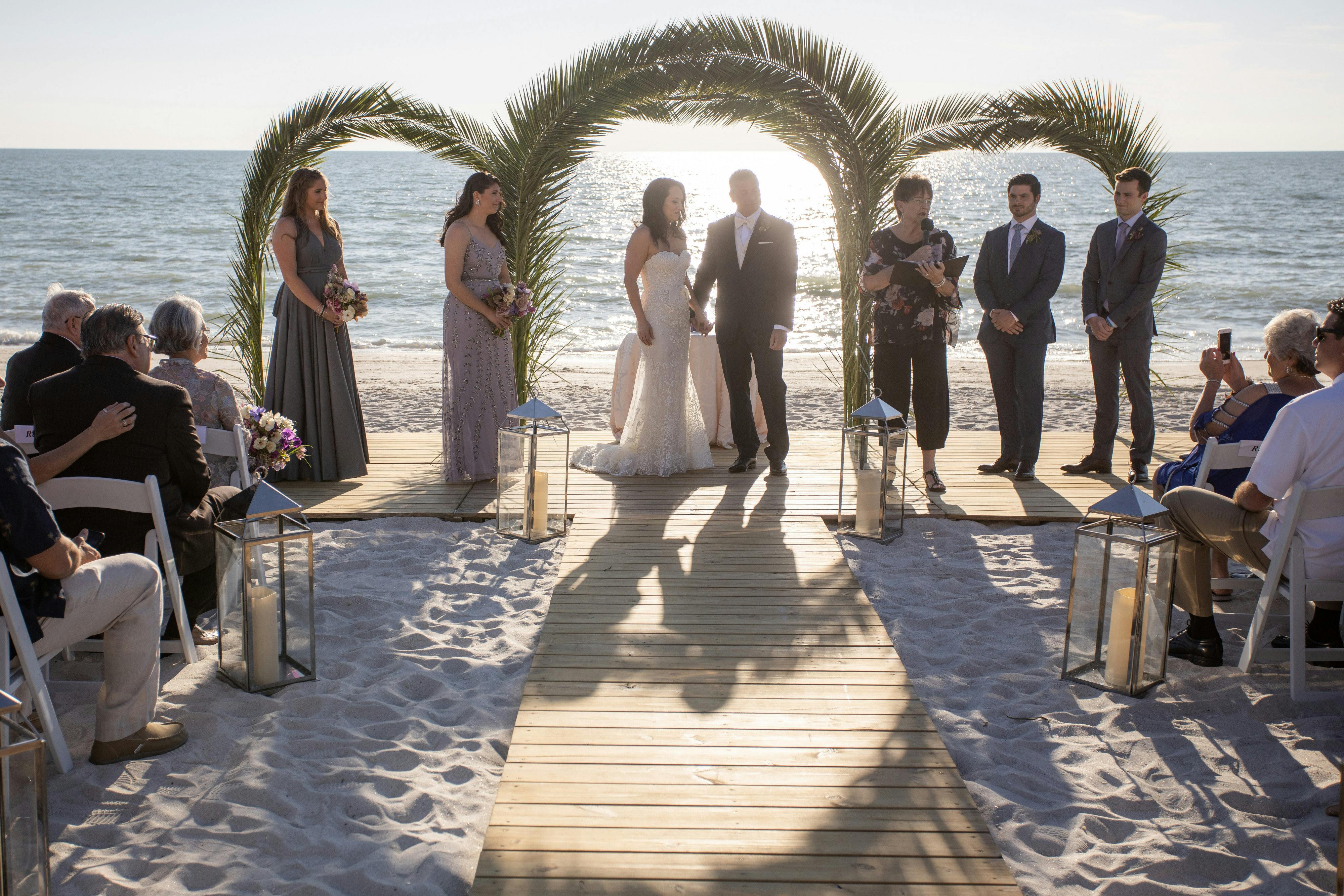 Three archways in front of blue water and a sandy beach