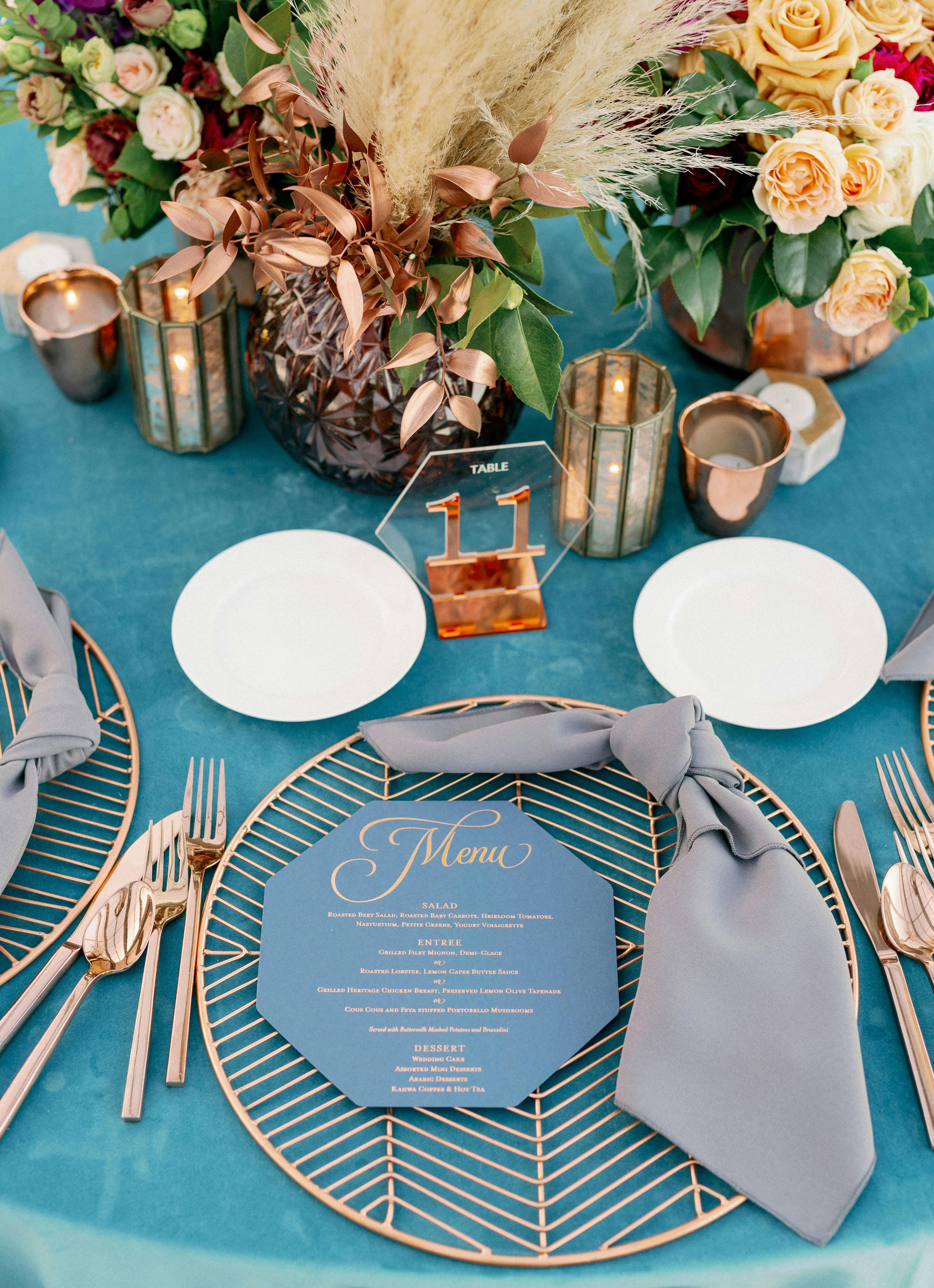 A tablescape with pampas grass and yellow florals and geometric accents.