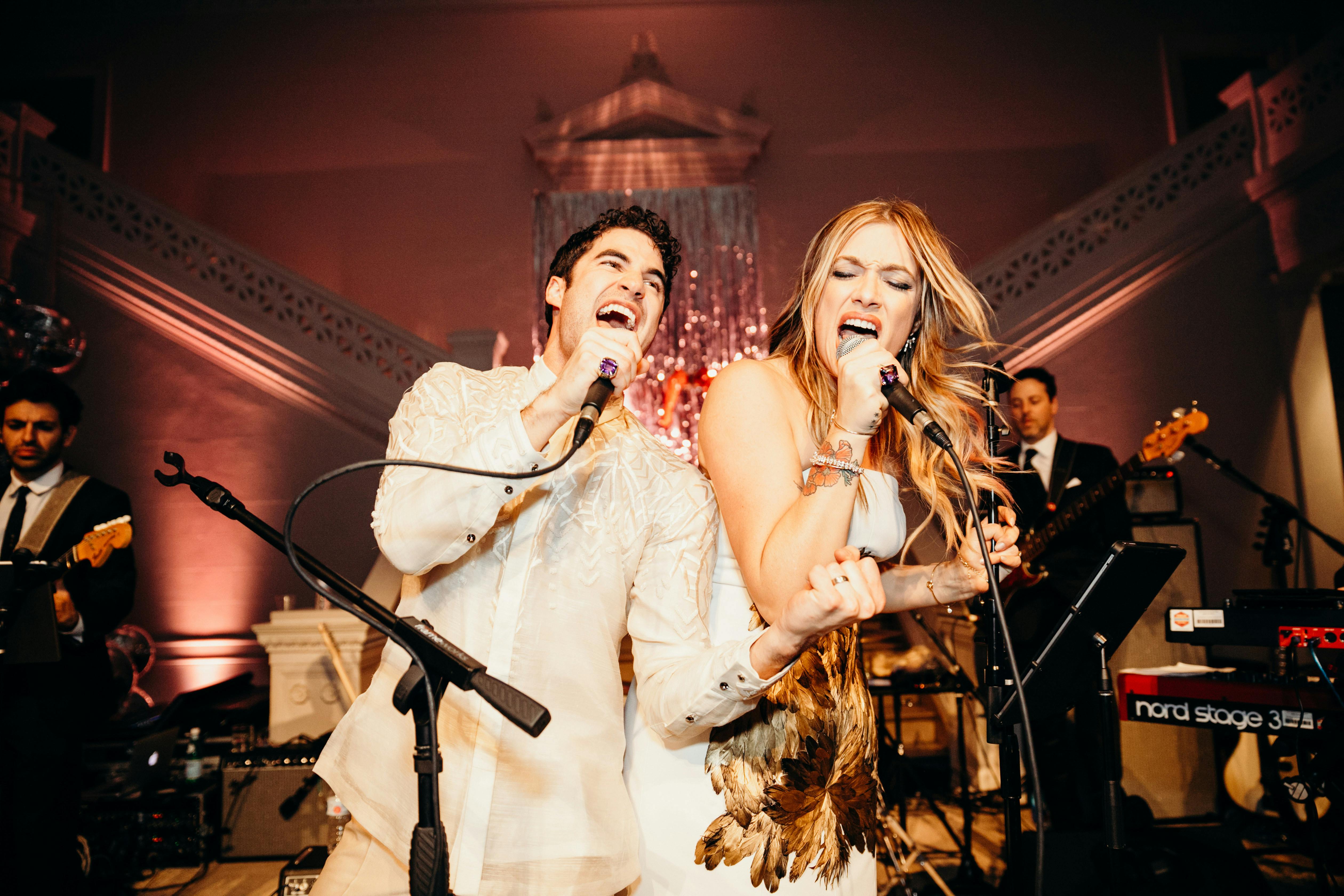 a couple sings onstage with vigor. 