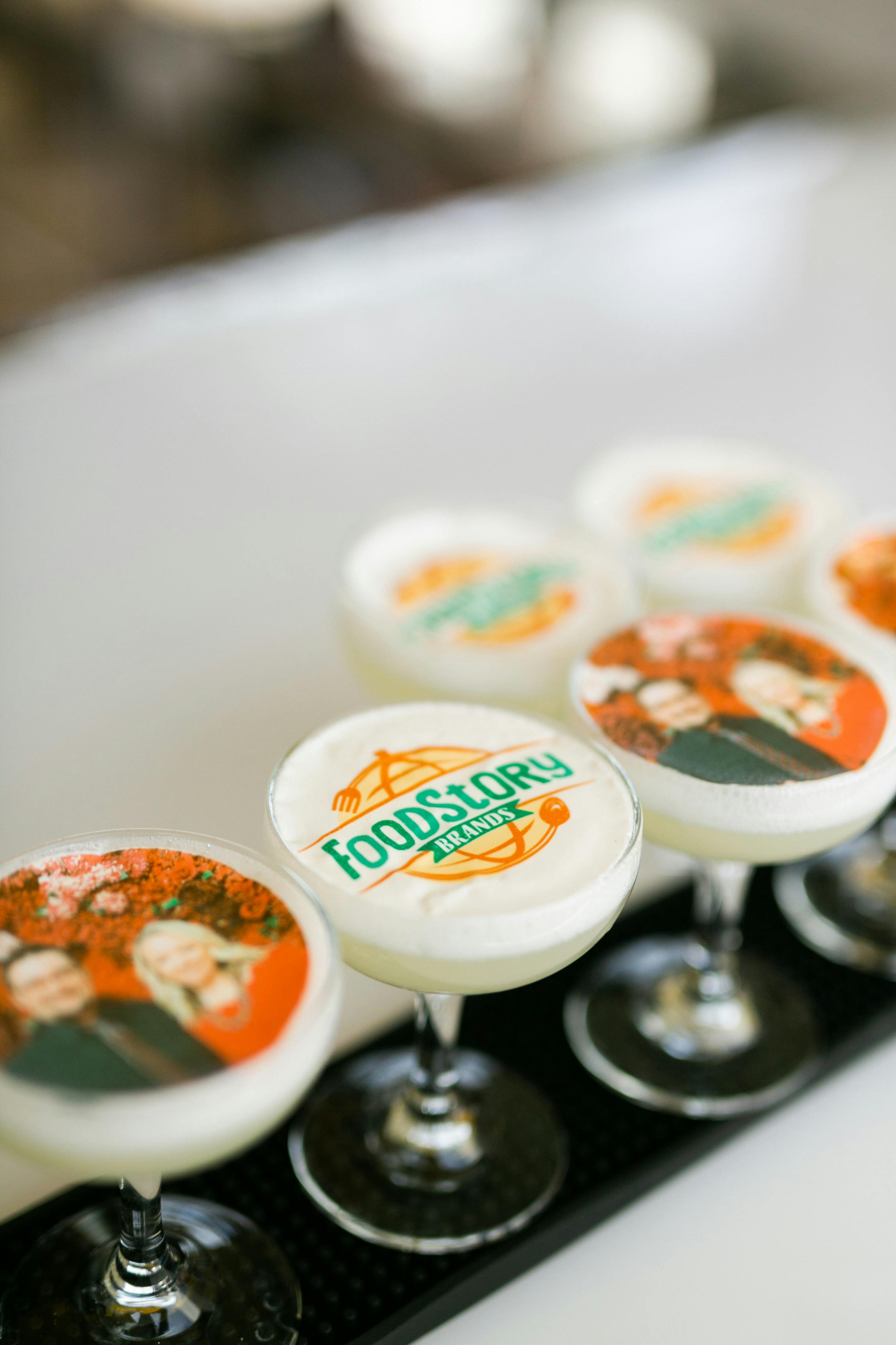 cocktails with pictures and logos floating on top