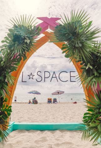 a palmed archway with orange lining shows the view to the beach. Branding is in the middle.