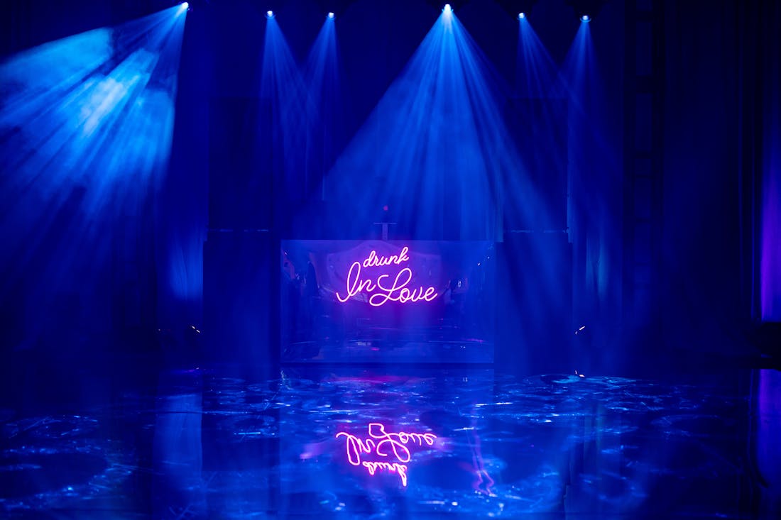 neon sign with drunk in love over blue lit dance floor